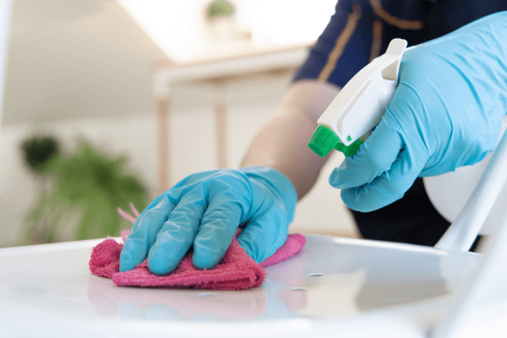 a person cleaning a surface with a pink cloth