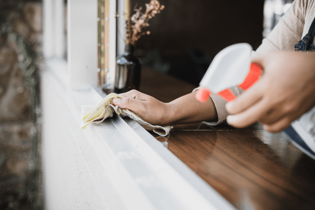 a hand holding a rag and cleaning a window