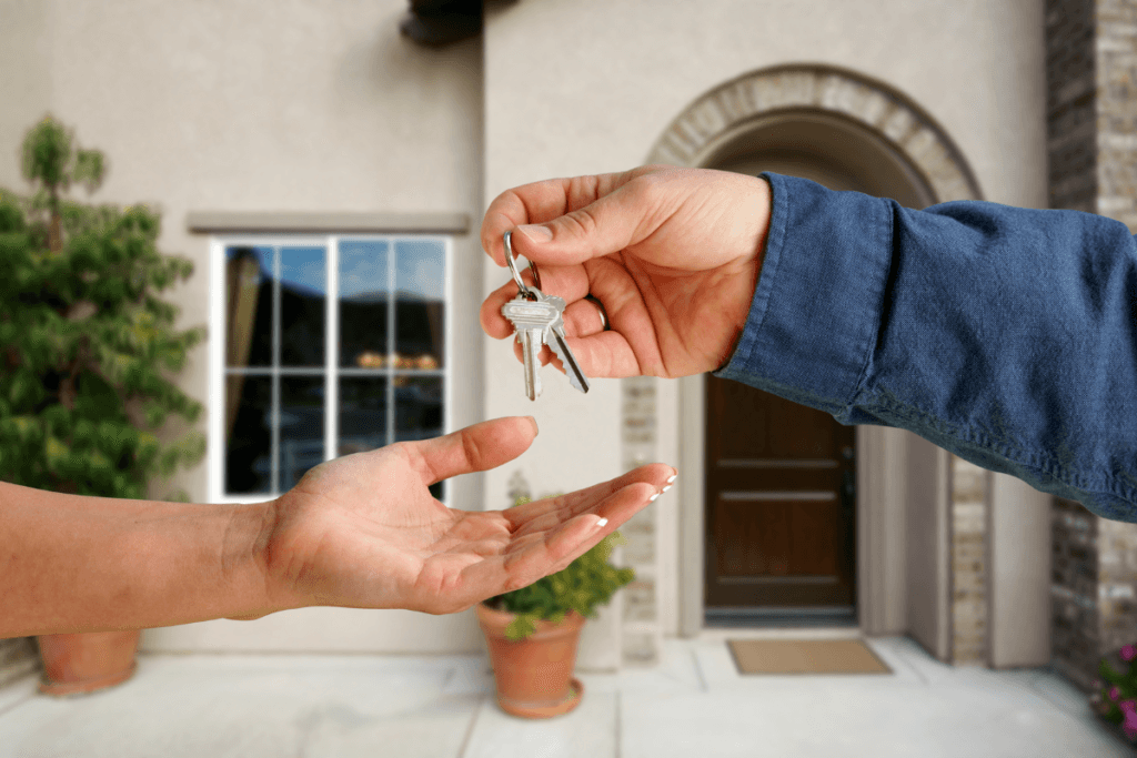 a hand handing over a key to another hand