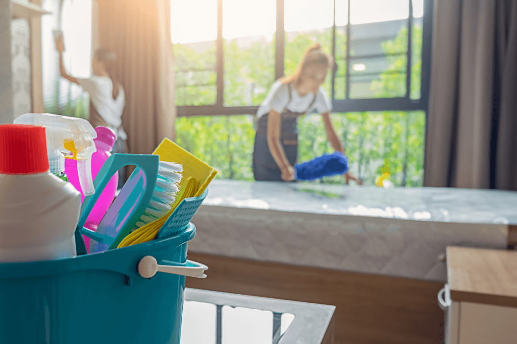 a bucket of cleaning supplies and a woman in the background