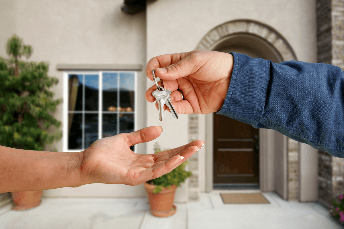 a hand handing over a key to another hand