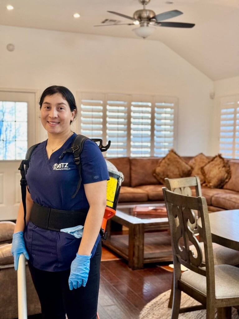 Yari with a backpack vacuum in a client's living room