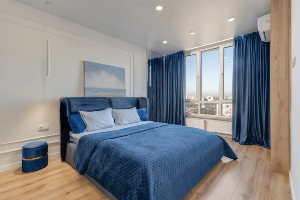 a bedroom with blue curtains and a bed