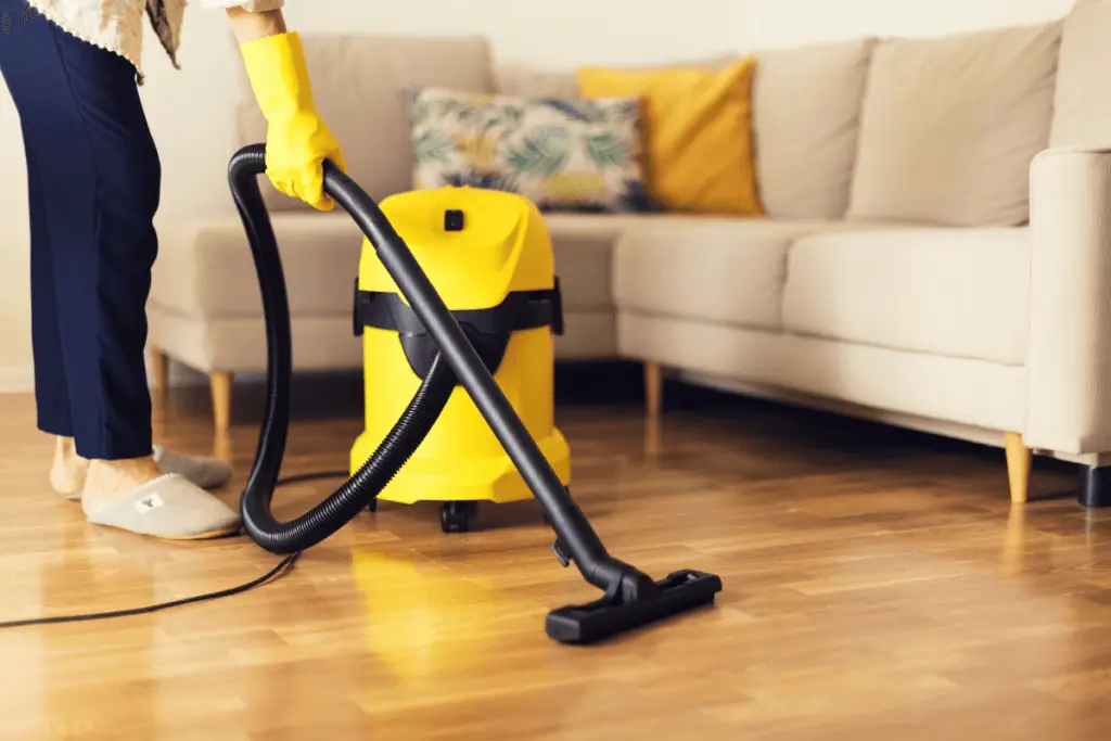 a person vacuuming a wood floor
