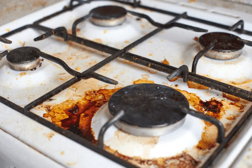 a dirty stove top with rust on top