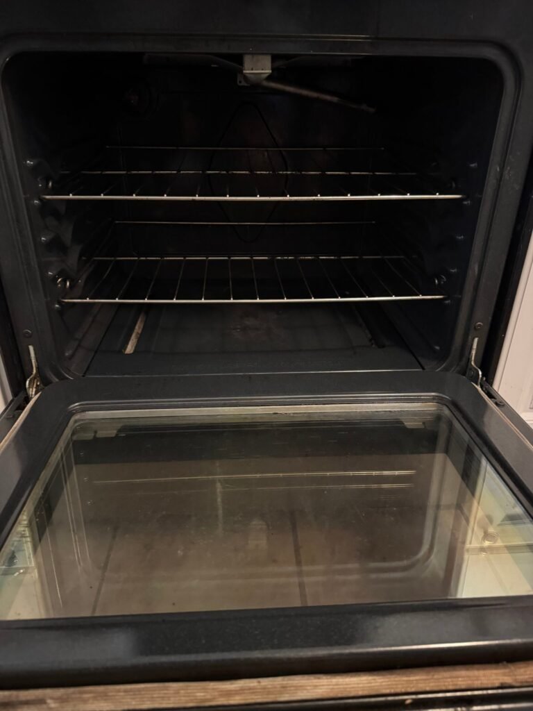 Same oven after cleaning, clean racks and clear glass door